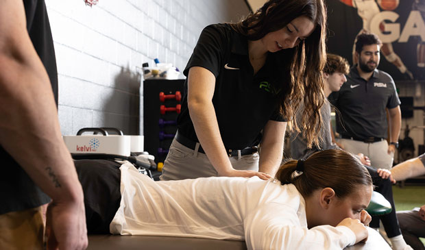 Athletic trainer working with athlete